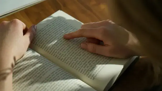 Person liest in einem Buch Lesen Deutsch B1: Diese deutschen Textsorten kommen im Test vor